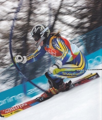 vedinja Anja Paerson, mojstrica slalom zavojev na zareznih smučeh med slalom vratci s pregibnimi kolci smuča leta 2006 v Torinu  svoji zlati olimpijski kolajni nasproti.