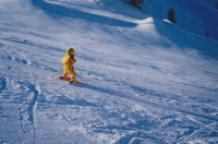  Otroci ne sodijo izven urejenih smučišč, saj so na običajnih progah bolj varni kot na primer fantič s čelado na sliki. V ozadju je pripravljen kup kompaktnega snega za vzdrževanje smučarskih prog (Alata Badia, Dolomiti, Italija, 2002).