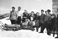 Turno smučanje ni bilo enostavno. Včasih si je smučar zlomil nogo. S Komne so ga do Savice v dolini prepeljali kar s sanmi za tovorjenje sena. Na sliki iz okoli leta 1955 bohinjski reševalci, Svetozar Guček – Zare za pomoč (drugi z leve), upravnica Doma na Komni (tretja z leve) in še tri pomočnice v Domu.