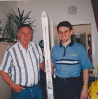 Desno mag Hannes Nothnagl sprejema iz rok Aleša Gučka darilo za muzej v Mürzzuschlagu ELAN vojaško smučko iz leta 1974 z vezjo JNA (prej naziv Antigips, patent dr. France Avčin, 1963). V zameno je Nothnagl podaril nekaj parov smučarskih vezi za dopolnitev 1. slovenske smučarske zbirke.