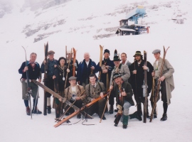 Mešana avstrijsko – slovenska skupina smučarjev po starem na prireditvi EMAUS na Kaninu leta 2003. Nekaj imen: spredaj v sredi čepi Borut Batagelj, danes doktor zgodovinskih znanosti, prvi, ki je v Sloveniji doktoriral iz zgodovine smučanja, levo zraven njega mag. Hannes Nothnagl, kustos muzej v Mürzzuschlagu, stoje z leve: Aleš Guček in nato člani skupine Batagelj oče Marjan, nečakinja Petra, sin Andrej ter svetovalec zgodovinske smučarske opreme Svetozar Guček.