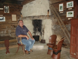  Aleš Guček sedi pred odprtim ognjiščem v Sondrejevi koči.