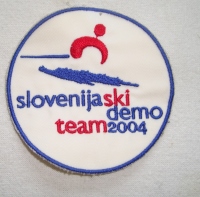 Našitek Slovenija Ski Demo Team, namesti pravilnega naziva Slovenian Ski Demo Team ali Demo Team of Slovenia (2004).